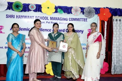 Student receiving a certificate and award from guests on stage