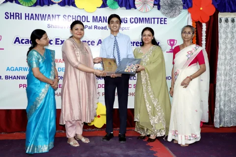 Prize distribution photograph of student with guests and principals