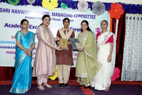 Student receiving award from chief guests at HSMC event